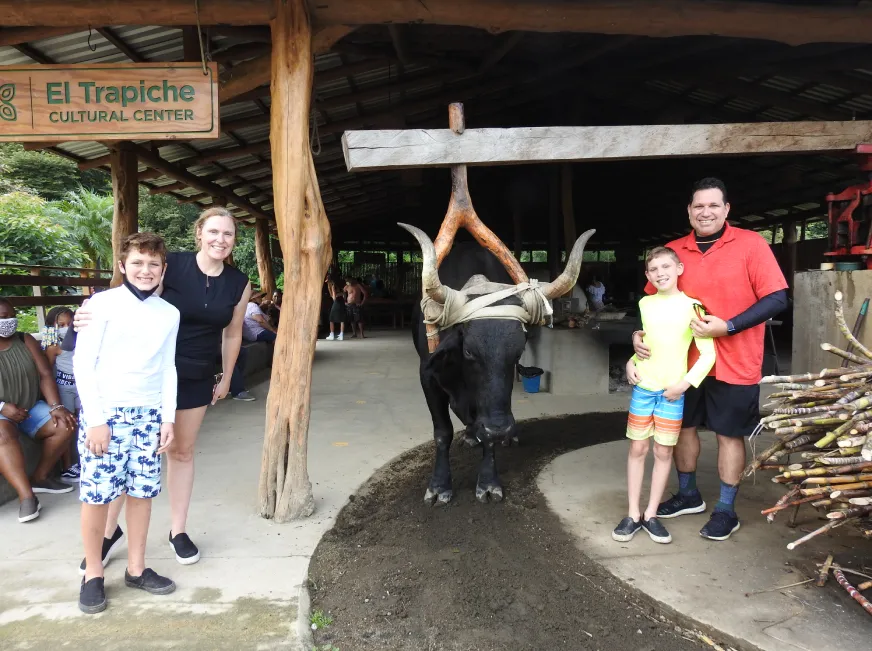 A group of tourists visit a local craft and souvenir shop with wooden decorations.